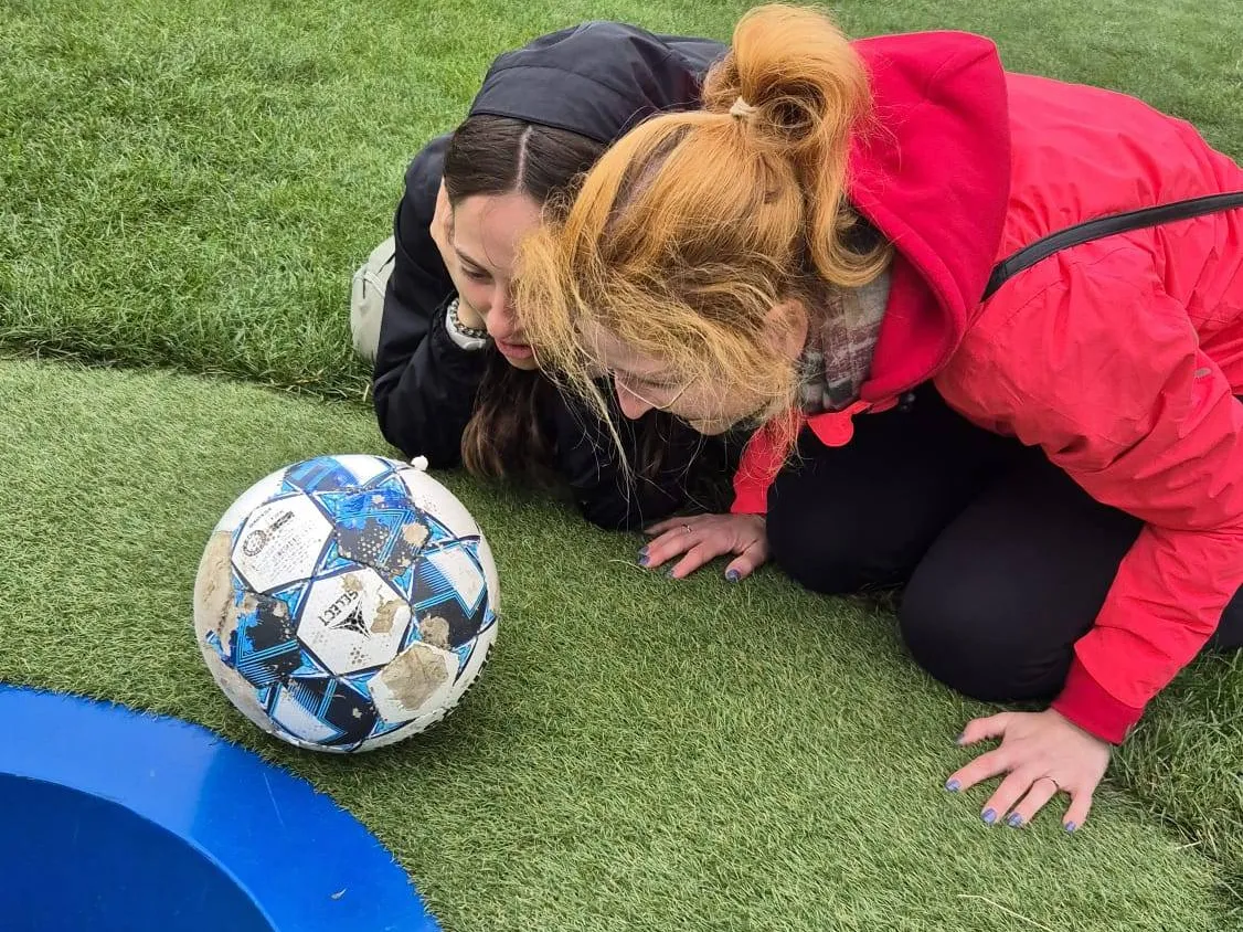 Zwei Tänzerinnen mit einem Fußball auf dem Rasen